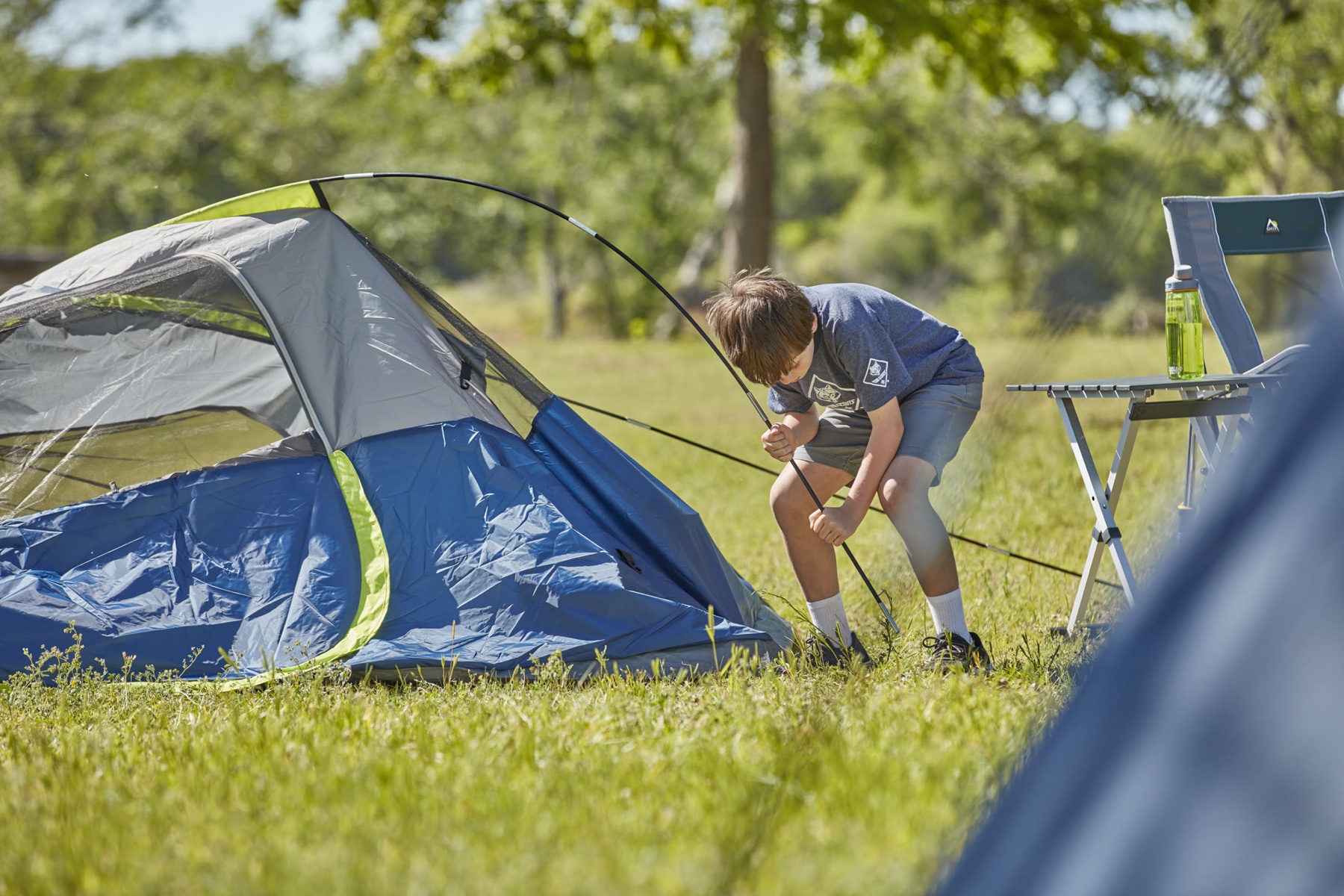 Cub Scout setting up a tent at a family campout